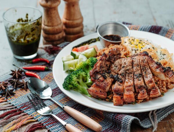 Balanced meal with grilled fish, brown rice, and colorful vegetables